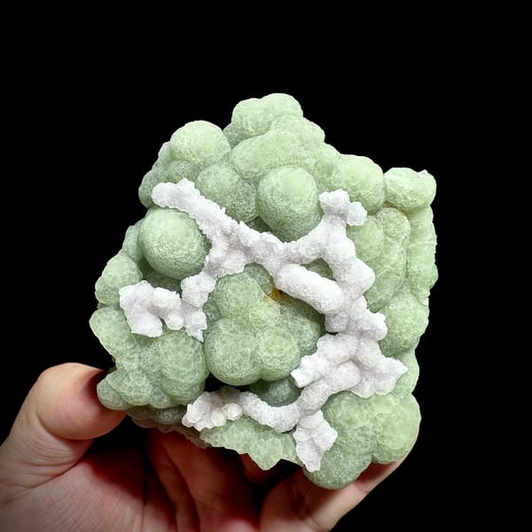 Pale green fluorite balls under lattice of white fluorite from Henan, China, close-up of the crystal faces