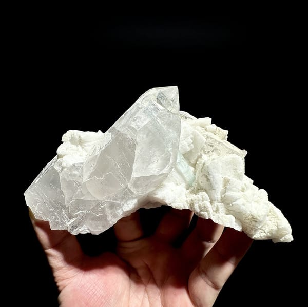 Pale aquamarine prism crossing clear quartz on feldspar from Pakistan, detail of the matrix contact