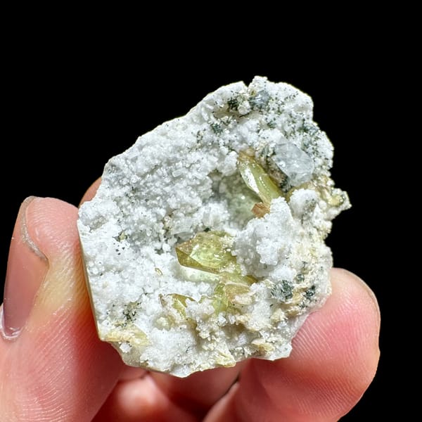 Yellow-green titanite crystals in white feldspar pocket from Pakistan, close-up of the crystal faces