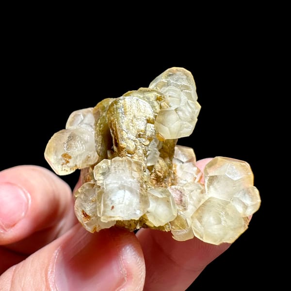 Translucent calcite rhombs around golden siderite from Guizhou, China, close-up of the crystal faces
