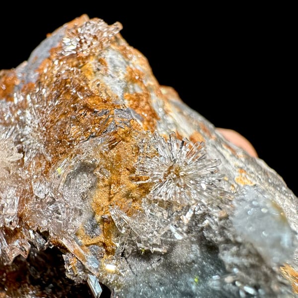 Transparent creedite flower sprays on rust-orange matrix from Guizhou, China, reverse side