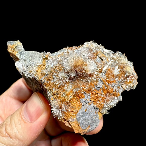 Transparent creedite flower sprays on rust-orange matrix from Guizhou, China, top view