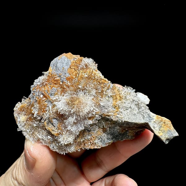 Transparent creedite flower sprays on rust-orange matrix from Guizhou, China, detail of the matrix contact
