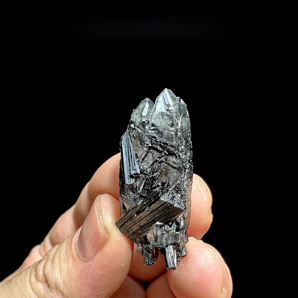 Clear quartz floater enclosing black tourmaline needles from Guangxi, China, detail of the matrix contact