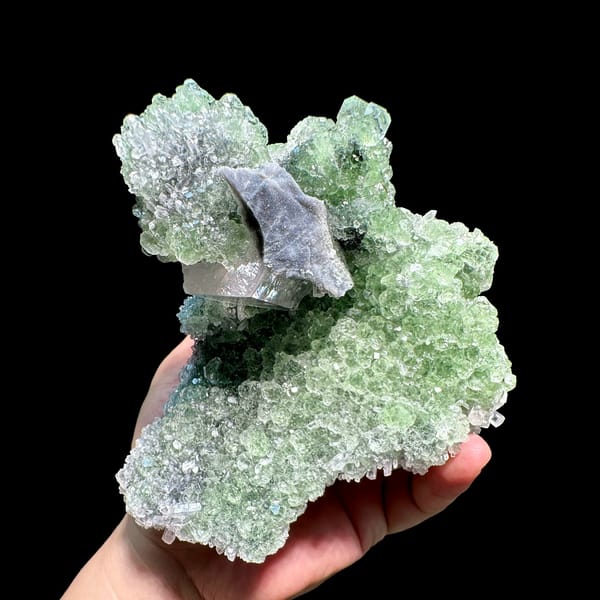 Large frosted calcite crystal on pale green fluorite and quartz from Fujian, China, close-up of the crystal faces
