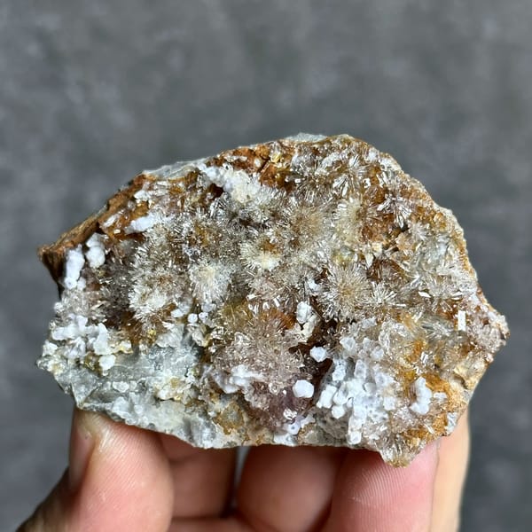Creedite flowers over pale purple yttrofluorite from Guizhou, China, close-up of the crystal faces