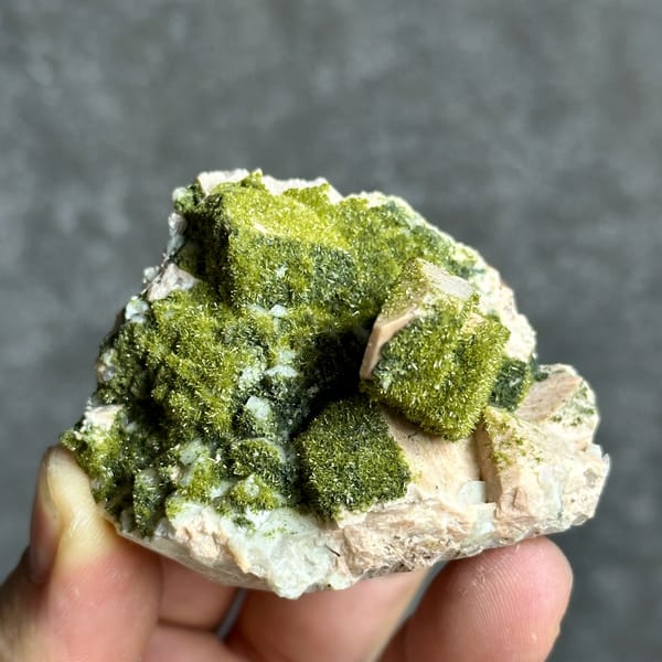 Lime-green epidote-coated feldspar prism on white base from Yunxiao, Fujian, China, reverse side