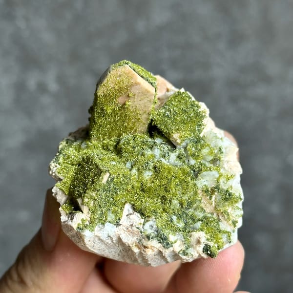 Lime-green epidote-coated feldspar prism on white base from Yunxiao, Fujian, China, top view