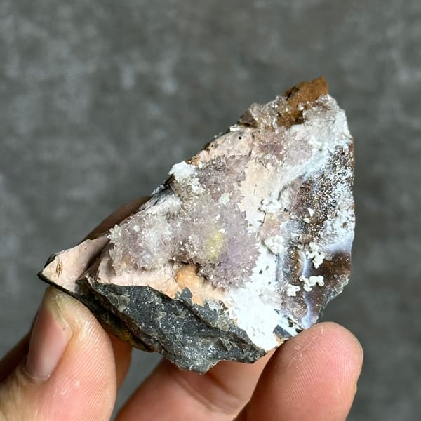 Purple and yellow creedite balls on grey matrix from Guizhou, China, close-up of the crystal faces