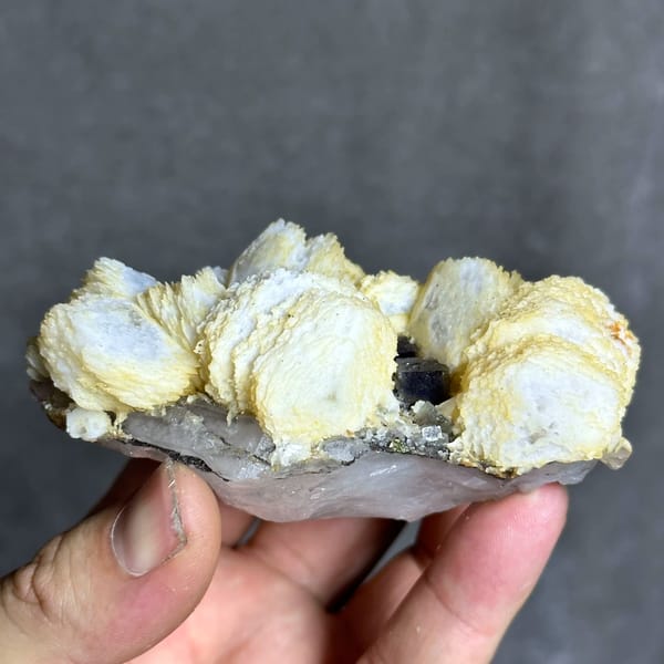 Cream calcite rosettes with fluorite cube and chalcopyrite from Yaogangxian Mine, Hunan, China, top view