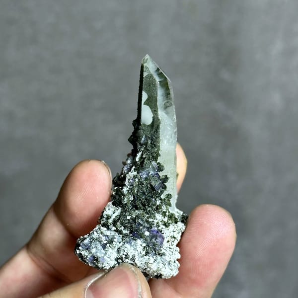 Tall clear quartz prism with purple fluorite and mica from Yaogangxian Mine, Hunan, China, close-up of the crystal faces