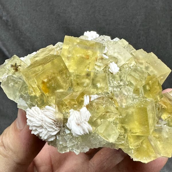 Mound of glassy lemon-yellow fluorite cubes with baryte from Beijing, China, close-up of the crystal faces