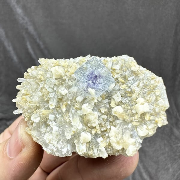 Pale blue fluorite cube on cream dolomite and quartz from Inner Mongolia, China, detail of the matrix contact