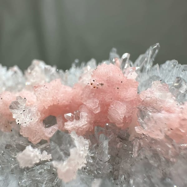 Band of pink rhodochrosite through white quartz needles from Guangxi, China, close-up of the crystal faces