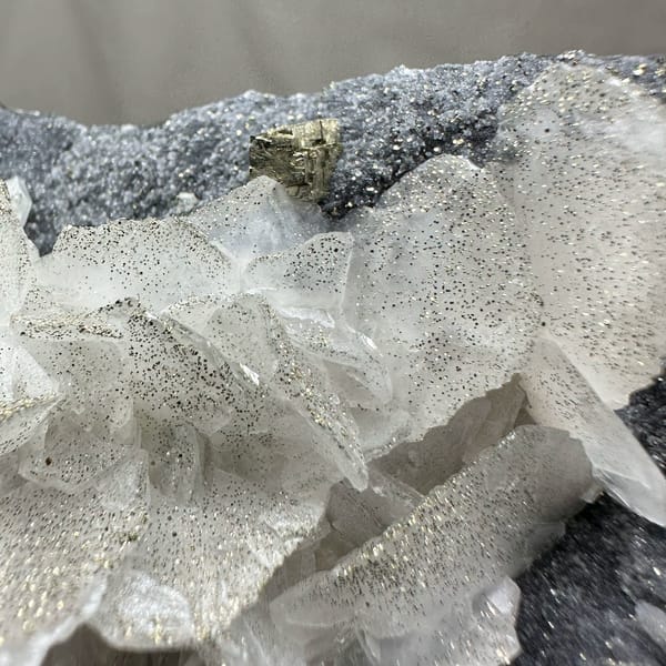 Frosted white calcite crystals on dark pyrite-dusted plate from Fujian, China, top view