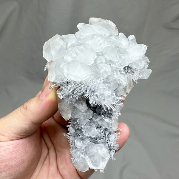 Floater of frosted quartz needles with calcite prisms from Fujian, China, close-up of the crystal faces