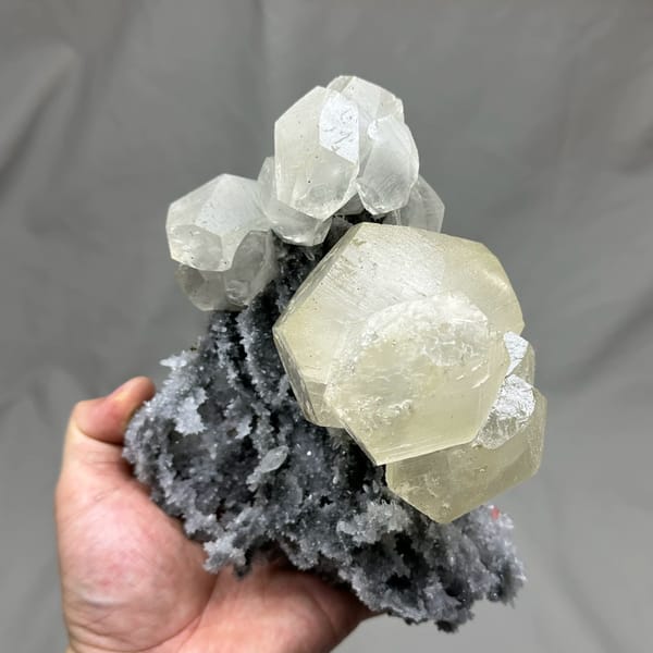 Large yellow-tinted calcite crystal on grey quartz from Fujian, China, close-up of the crystal faces