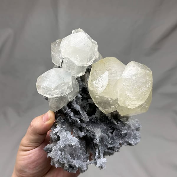 Large yellow-tinted calcite crystal on grey quartz from Fujian, China, reverse side