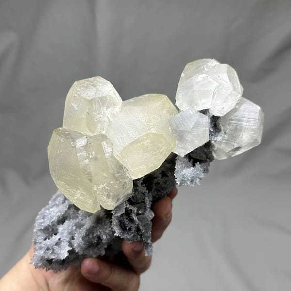 Large yellow-tinted calcite crystal on grey quartz from Fujian, China, top view