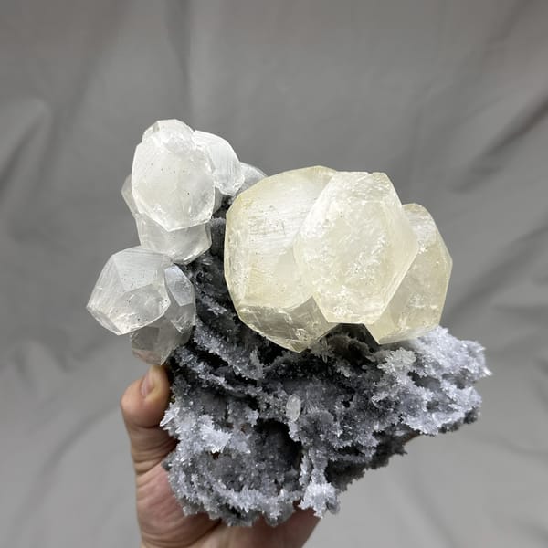 Large yellow-tinted calcite crystal on grey quartz from Fujian, China, detail of the matrix contact