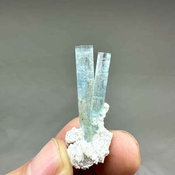 Two sea-blue aquamarine prisms on white feldspar from Namibia, second angle