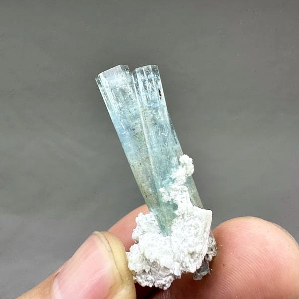 Two sea-blue aquamarine prisms on white feldspar from Namibia, top view