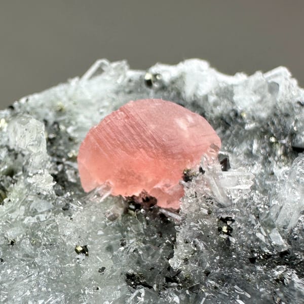 Pink rhodochrosite patch on dark quartz-and-pyrite plate from Guangxi, China, second angle