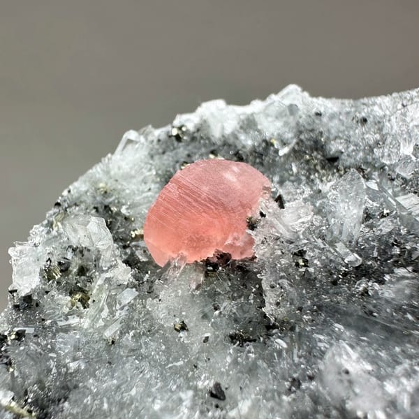 Pink rhodochrosite patch on dark quartz-and-pyrite plate from Guangxi, China, reverse side