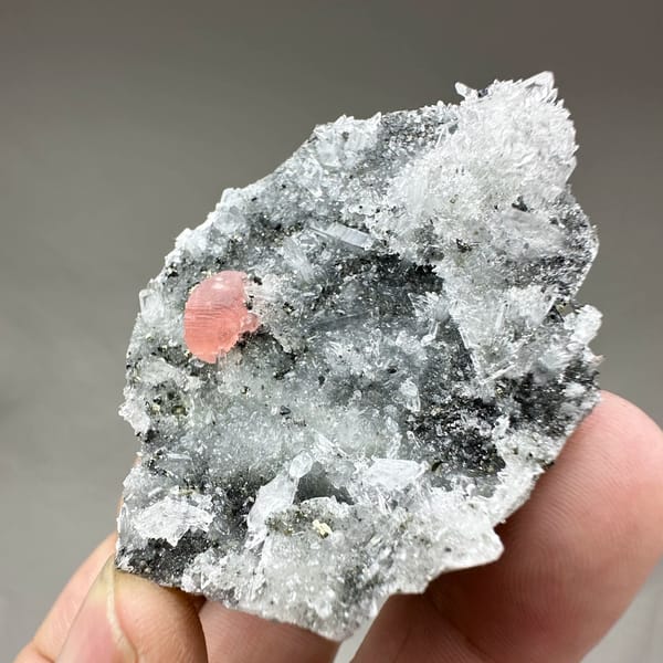Pink rhodochrosite patch on dark quartz-and-pyrite plate from Guangxi, China, top view