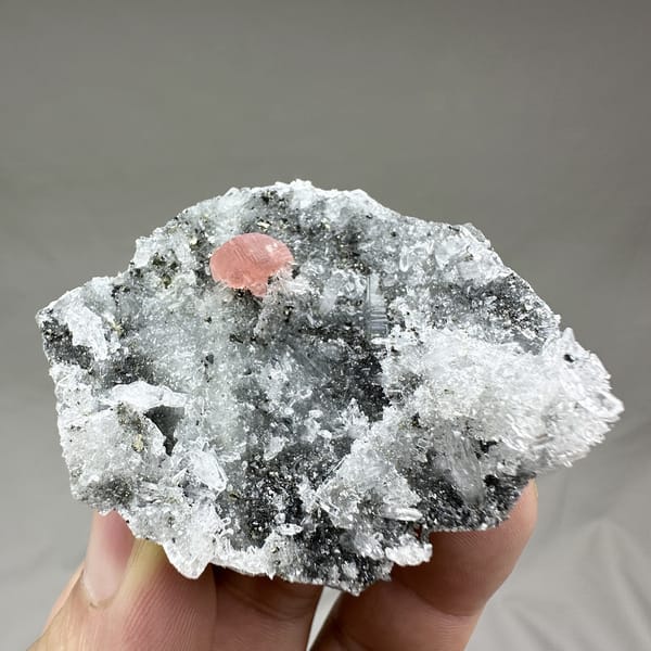 Pink rhodochrosite patch on dark quartz-and-pyrite plate from Guangxi, China, detail of the matrix contact