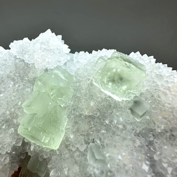 Transparent pale-green fluorite cubes on frosted white quartz from Guangdong, China, second angle
