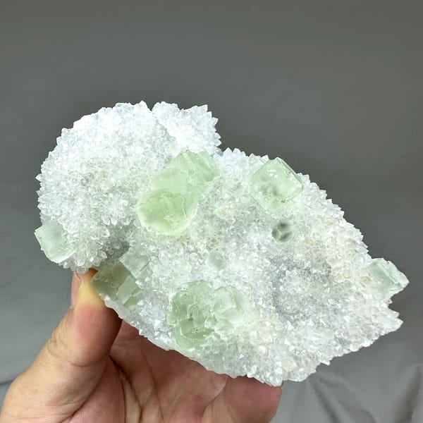 Transparent pale-green fluorite cubes on frosted white quartz from Guangdong, China, close-up of the crystal faces