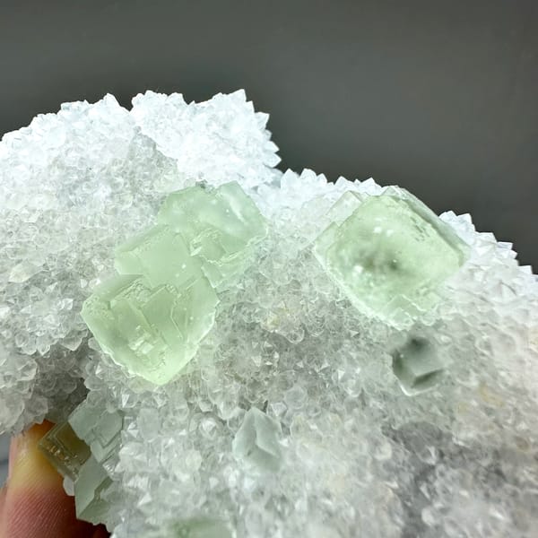 Transparent pale-green fluorite cubes on frosted white quartz from Guangdong, China, reverse side