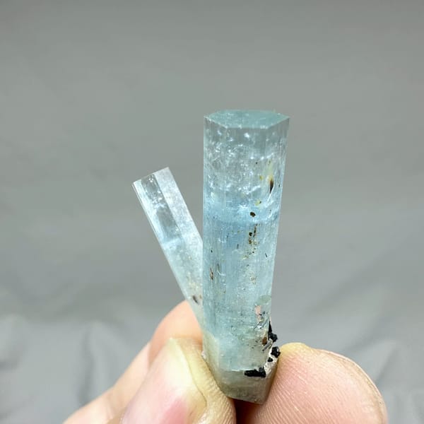 Two sky-blue aquamarine prisms with black tourmaline from Namibia, reverse side