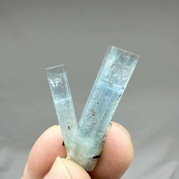 Two sky-blue aquamarine prisms with black tourmaline from Namibia, top view