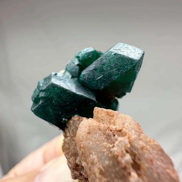 Large emerald-green dioptase crystals on pink matrix from DR Congo, second angle