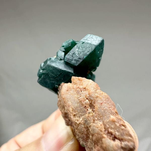 Large emerald-green dioptase crystals on pink matrix from DR Congo, top view