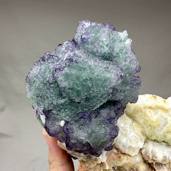Purple and green stepped octahedral fluorite over white quartz from Zhejiang, China, reverse side