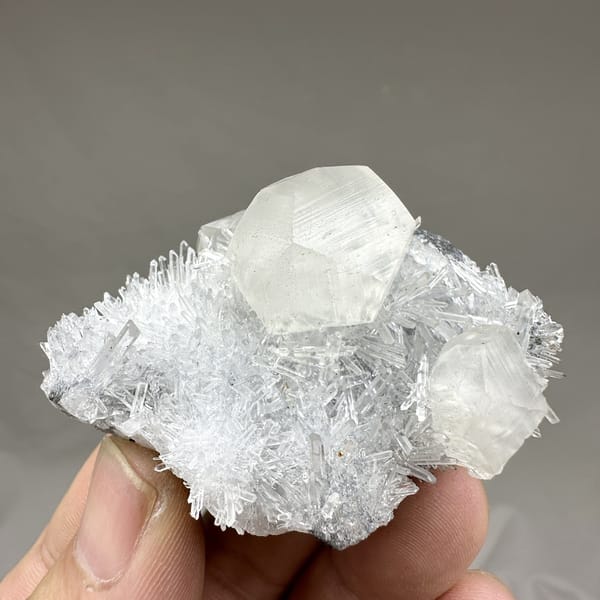 Large translucent calcite crystal in nest of quartz needles from Fujian, China, detail of the matrix contact