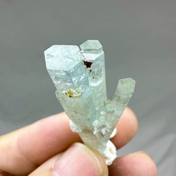 Sea-green aquamarine prism with white feldspar collar from Namibia, close-up of the crystal faces