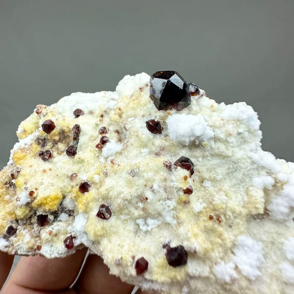 Large dark garnets with hyalite opal on cream feldspar from Yunxiao, Fujian, China, reverse side