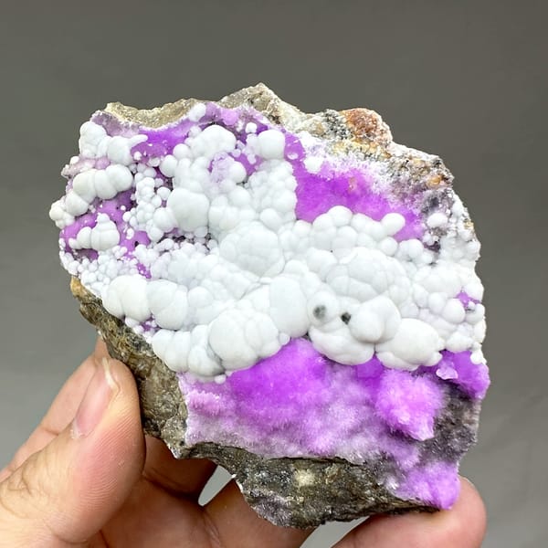 White aragonite balls in field of violet aragonite from Yunnan, China, close-up of the crystal faces
