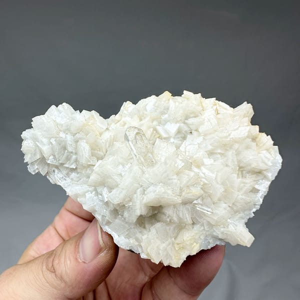 Plate of cream dolomite rhombs with clear quartz from Guizhou, China, held in hand