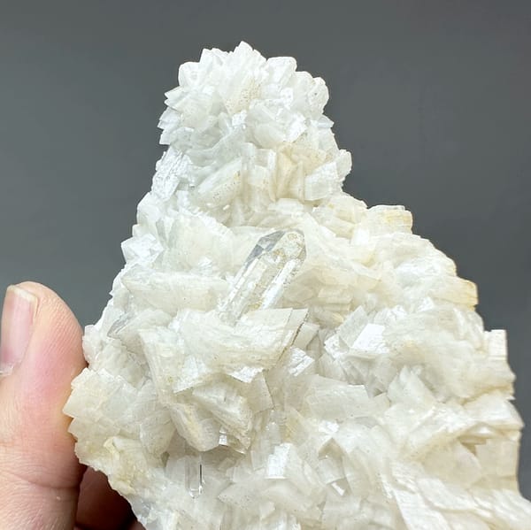 Plate of cream dolomite rhombs with clear quartz from Guizhou, China, close-up of the crystal faces