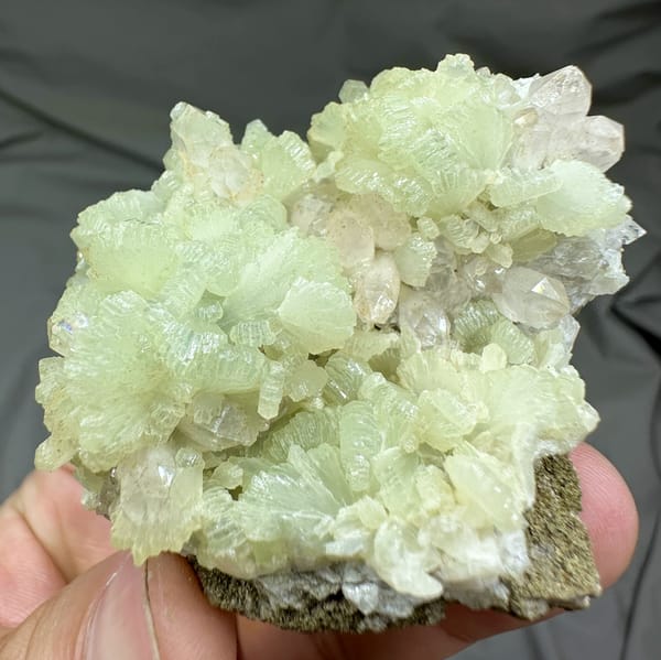 Pale green fan-shaped prehnite with quartz points from Morocco, close-up of the crystal faces