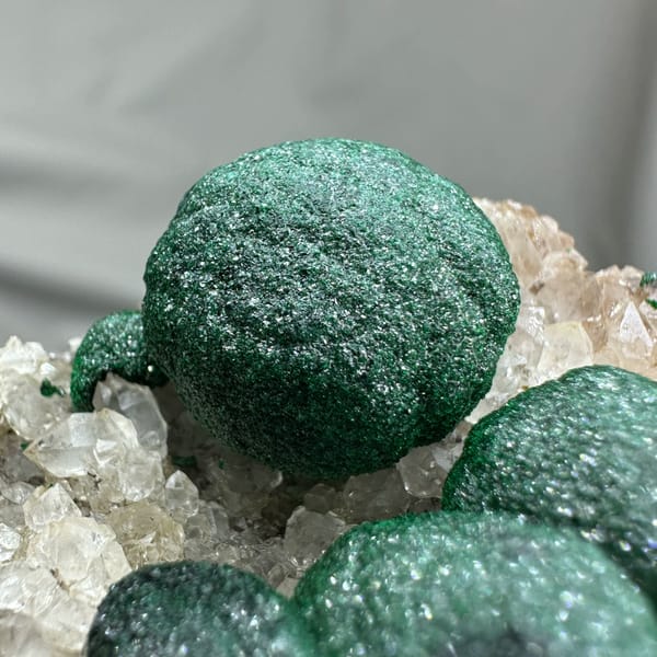 Three large velvet-green malachite balls on white quartz from DR Congo, second angle
