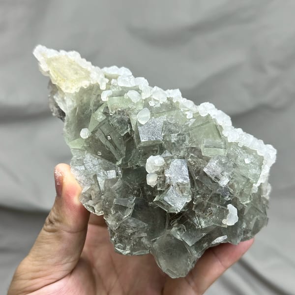 Pale grey-green fluorite cubes with white calcite on plate from Xianghualing, Hunan, China, close-up of the crystal faces
