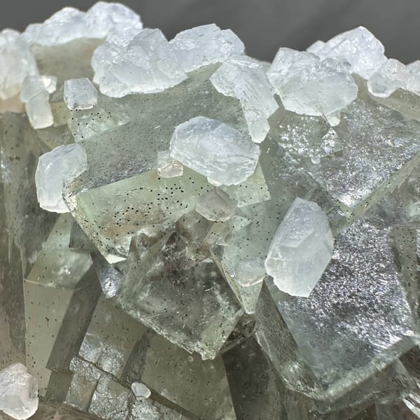 Pale grey-green fluorite cubes with white calcite on plate from Xianghualing, Hunan, China, reverse side