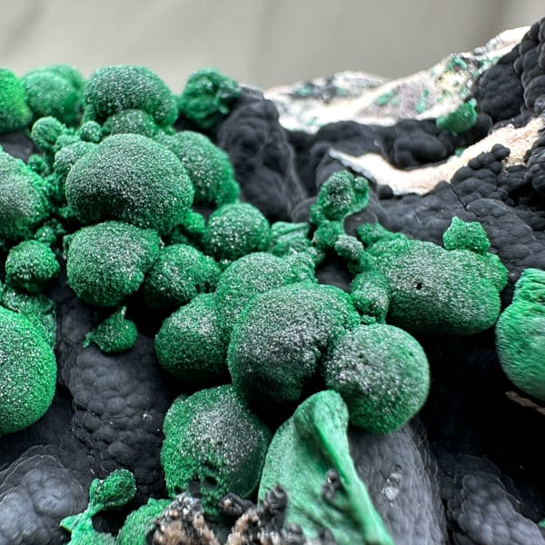 Green malachite balls over black manganese oxide from DR Congo, second angle