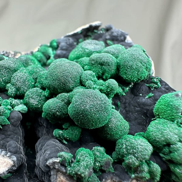 Green malachite balls over black manganese oxide from DR Congo, top view